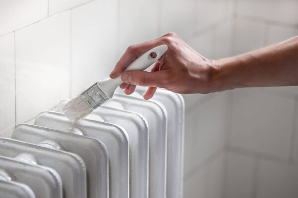 Closeup,Of,Female,Hand,Painting,Old,Aluminum,Heating,Radiators,With