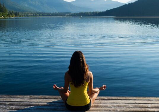 Easy Pose Tranquil Lakeside meditation at sunrise Female meditating doing sukhasana or Easy Pose during a yoga working at a pristine mountain lake