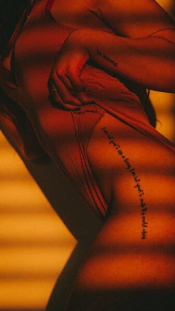 Portrait of a model with a hip tattoo photographed in golden evening sunlight during an available light photoshoot.