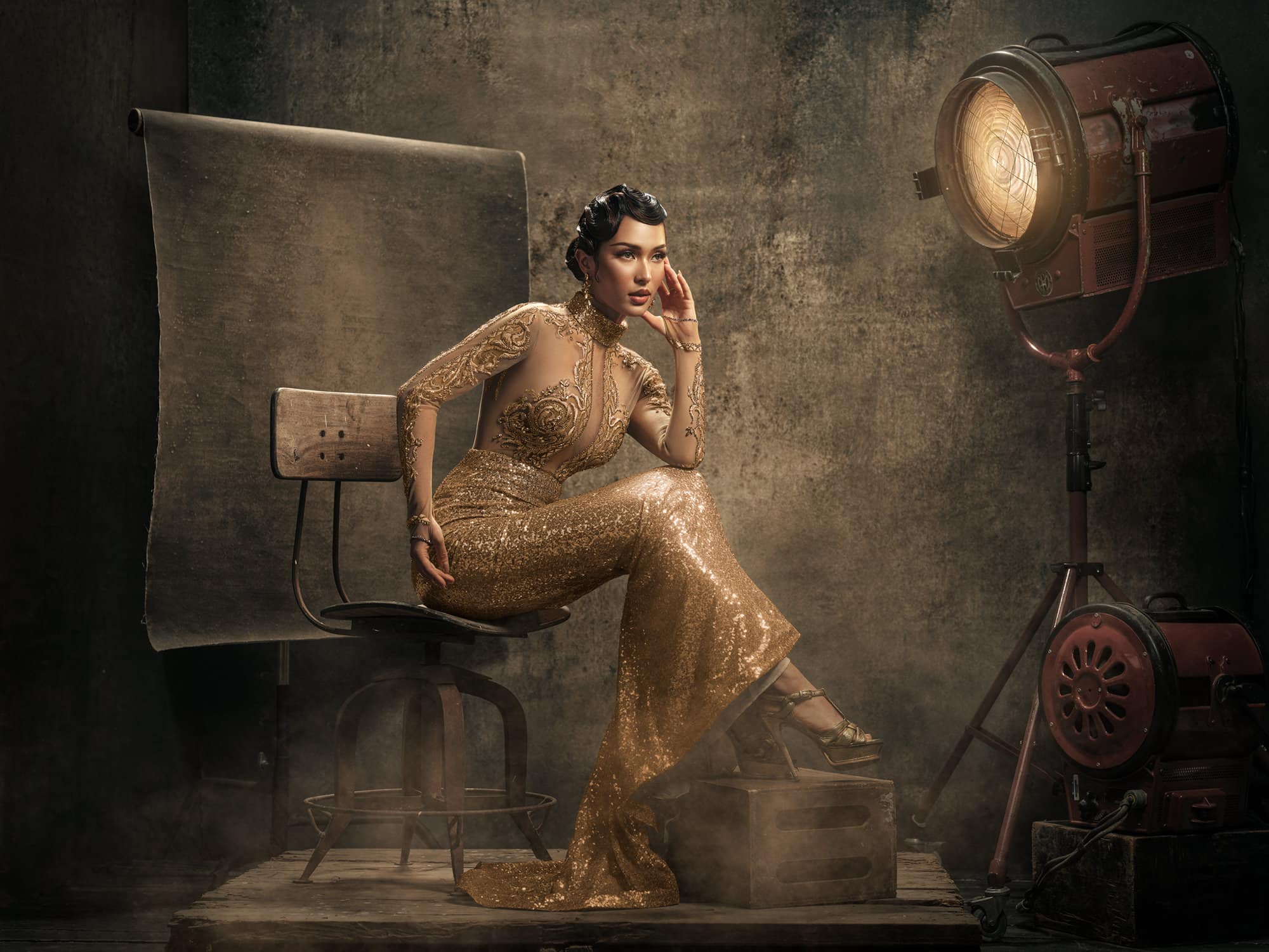 Porträt einer asiatischen Frau in einem mit Gold verzierten Abendkleid, inszeniert mit Vintage-Hollywood-Beleuchtung, Film-Scheinwerfern im Stil der 1920er Jahre, im „Corporate-Diva“-Stil und mit klassischem filmischem Glamour.
