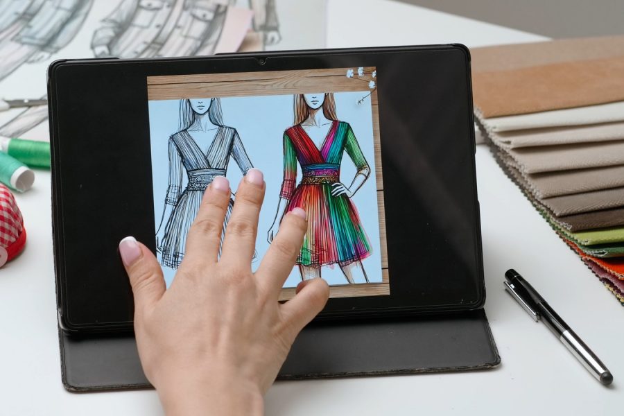 Woman,Fashion,Designer,Works,On,Digital,Graphic,Tablet,Touch,Screen Woman fashion designer works on digital graphic tablet touch screen with illustration of clothing collection sketch. Creativity and modern technology.