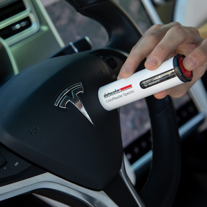 Person using the colorreader device on a car steering wheel