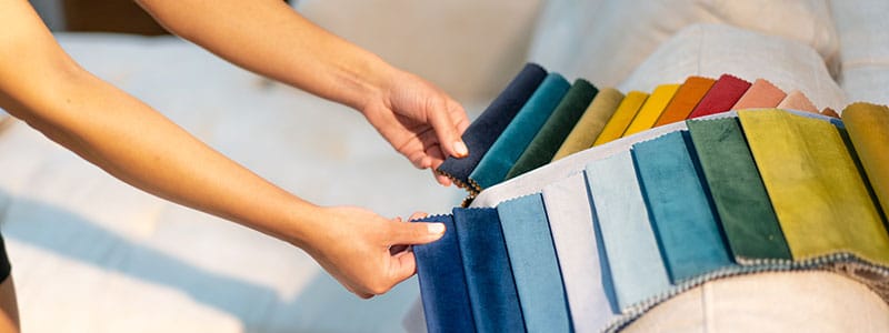 Hands comparing textile color samples.