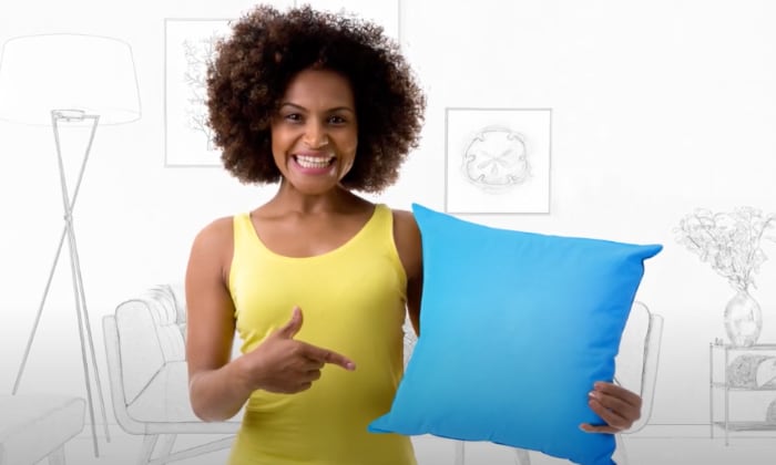 woman in yellow tank holding a blue pillow