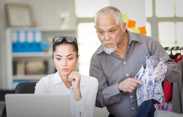 people looking at computer comparing fabric colors