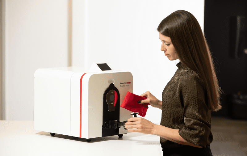 woman using spectrophotometer to measure fabric